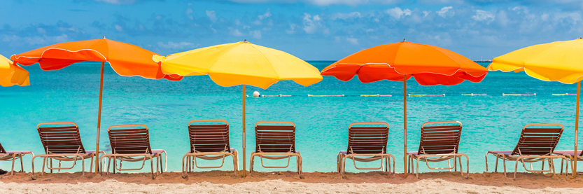 Row of beach chairs and umbrellas on a sunny beach