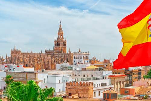 Skyline of Seville Cathedral and a Spanish flag