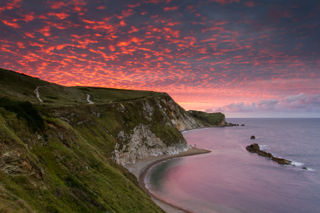 Dorset coastline with pink skies, sea and white cliffs