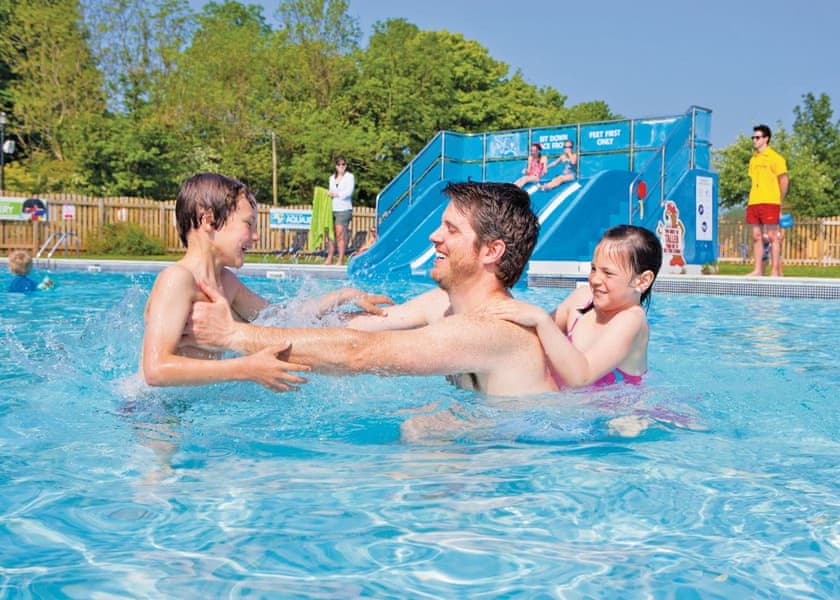 Family enjoying the swimming pool at accessible holiday park in Wales