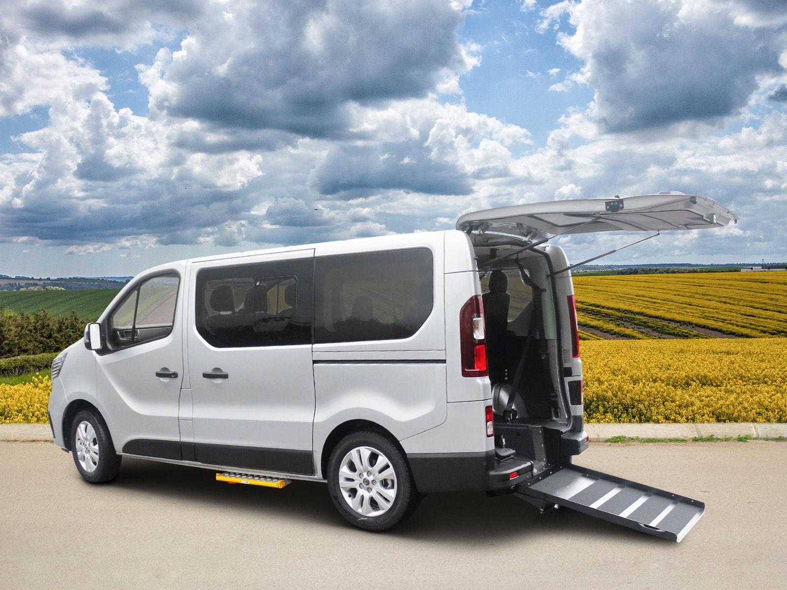 Image of an adapted van with its ramp extended and rear door open.
