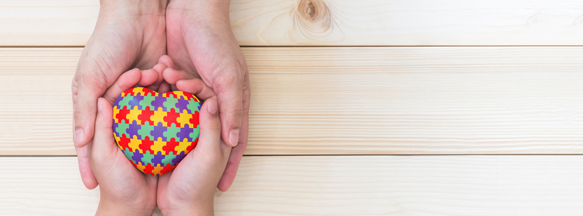 Autism heart logo in hands