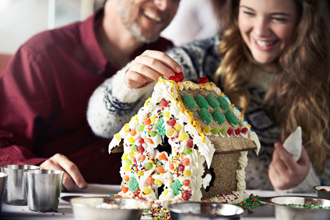 Couple making a gingerbread house on a Princess Christmas cruise