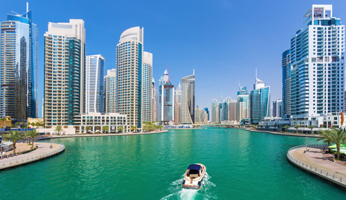Speed boat sailing past skyscrapers in Dubai Marina