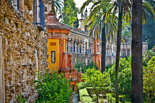 Lush greenery and ornate decorations in the Real Alcazar gardens, Seville, Spain