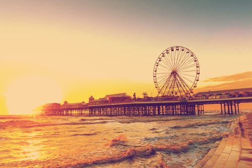 Blackpool pier and ferris wheel against the sea and sky at sunset. Blackpool, UK.