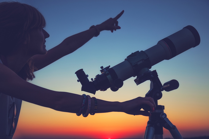 Girl stargazing with telescope