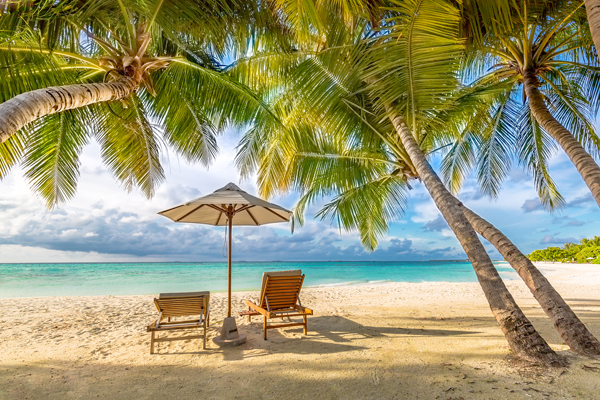 Two beach chairs on a sandy tropical beach